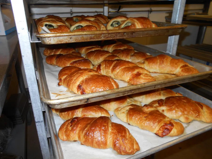 Trays of golden croissants and spinach pastries fresh from the oven